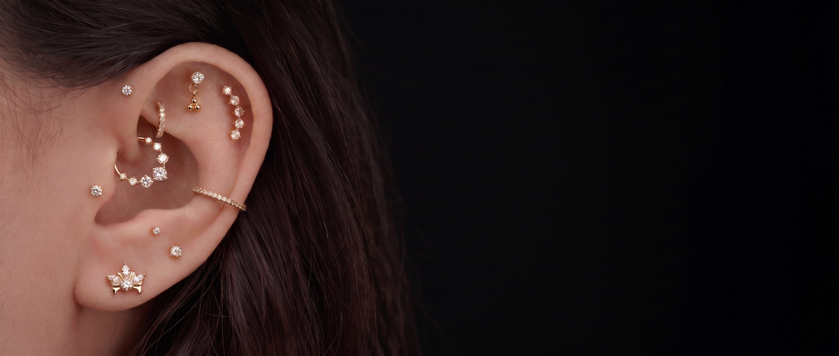 Oreja con joyería para piercing sobre fondo negro